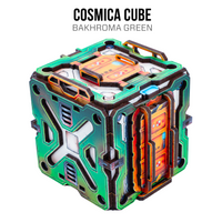 A futuristic cube-shaped product labeled 'COSMICA CUBE' and 'BAKHROMA GREEN' on a plain white background. The cube has a metallic green and teal outer shell with orange inner panels, black structural outlines, and small blue details.